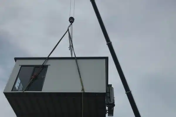 Building Lifted Over House with Crane